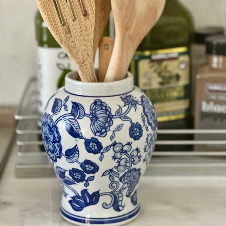 Wooden utensils in a blue and white ceramic container on a kitchen counter.