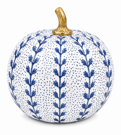 A decorative ceramic pumpkin with a white glaze, decorated with blue botanical leaf patterns and tiny blue dots, topped with a metallic gold stem, shown on a plain white background.