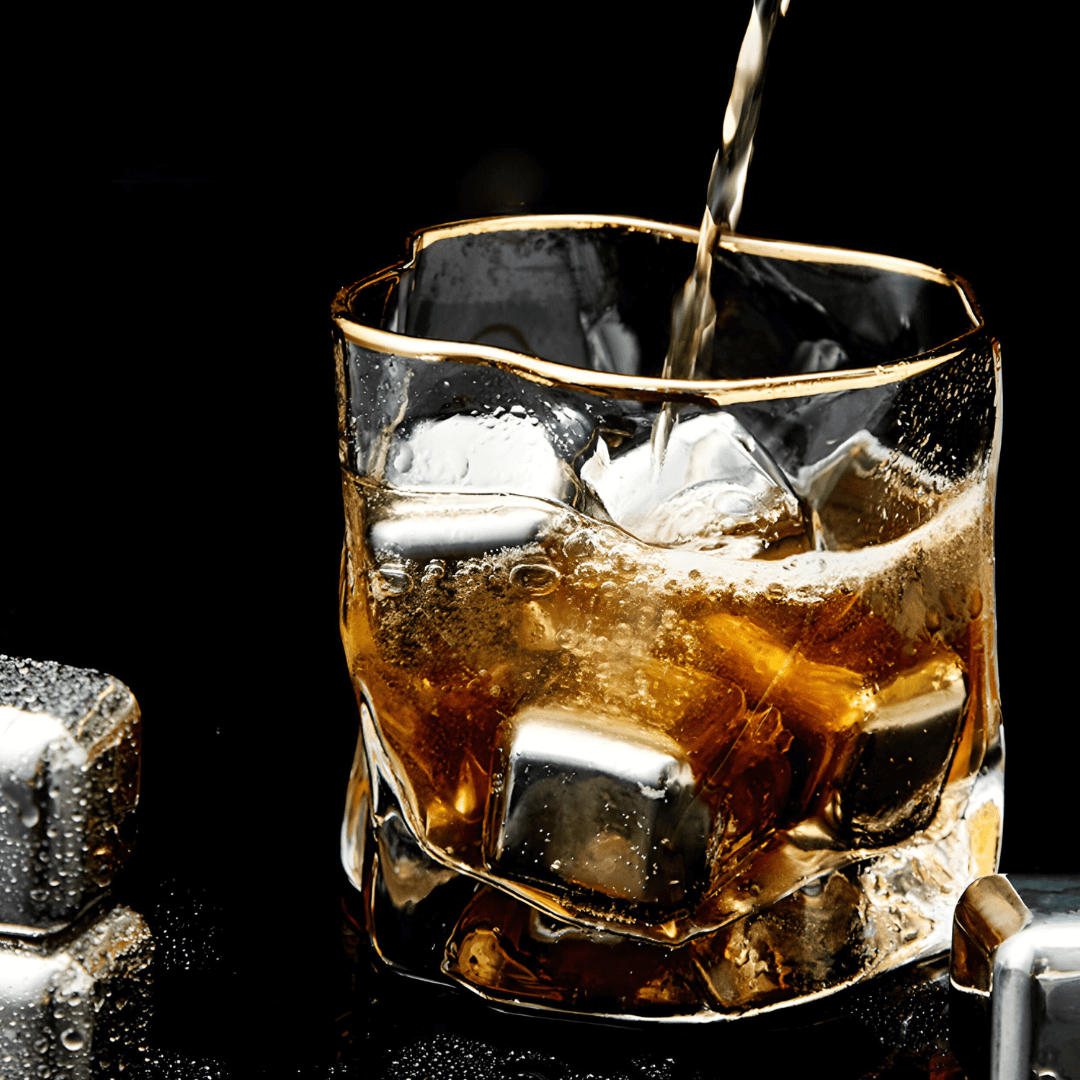 Glass of whiskey with ice being poured against a black background