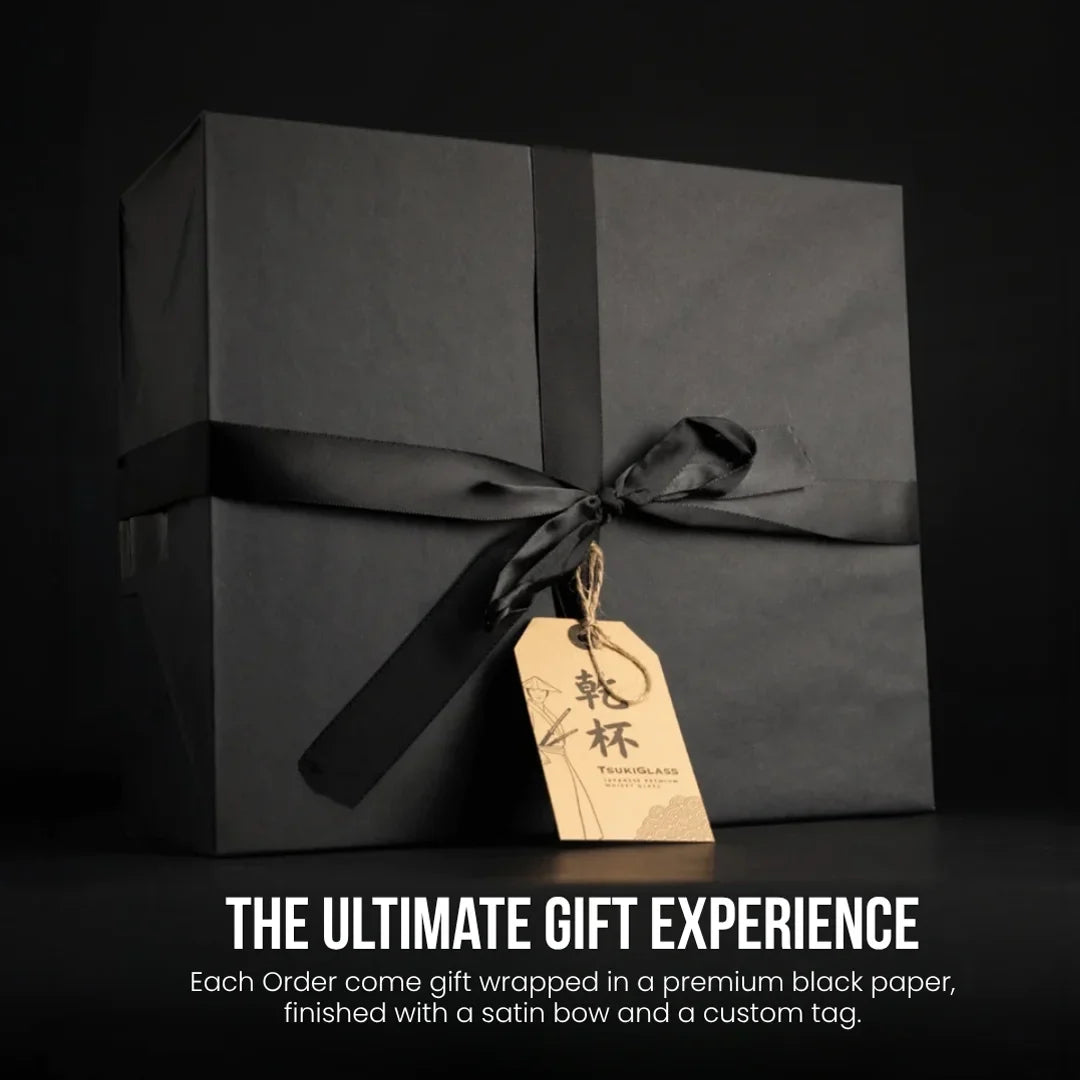 Black gift box with satin bow and custom tag on a black background, featuring text about the ultimate gift experience.