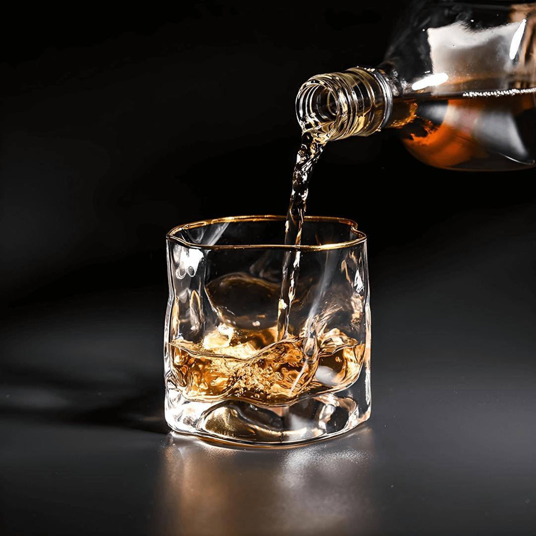 Whiskey being poured into a glass with ice cubes on a dark background