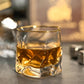 Glass of whiskey with a gold rim on a dark surface