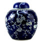 Blue ceramic jar with white floral patterns on a white background