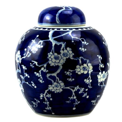 Blue ceramic jar with white floral patterns on a white background