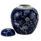 Blue ceramic jar with white floral patterns on a white background
