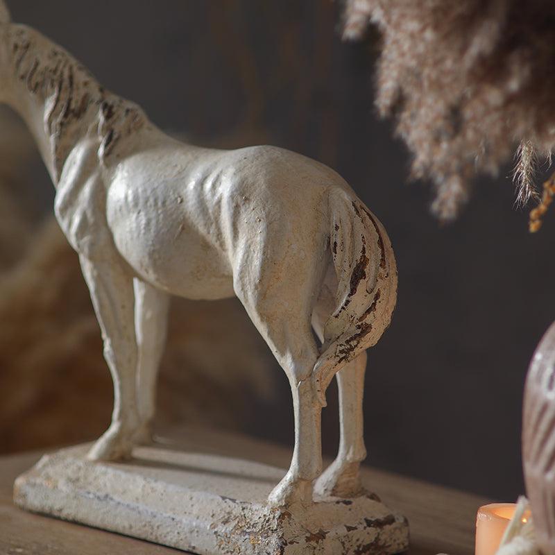 Statue of a horse on a wooden surface with a blurred background